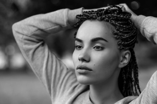 A black-and-white portrait of a beautiful girl with plaited braids. - Photo, Image