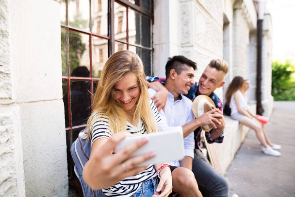 Group of students in front of university taking selfie. - Valokuva, kuva