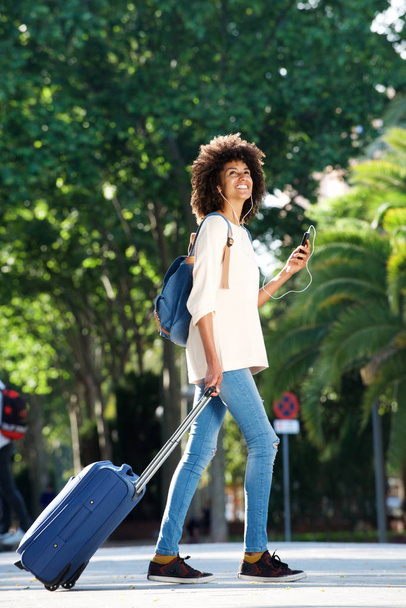  viaggiatore che cammina con valigia e telefono
 - Foto, immagini