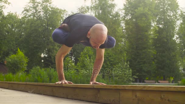 Ένας άνθρωπος που κάνει Γιόγκα ασκήσεις στο πάρκο - Πλάνα, βίντεο