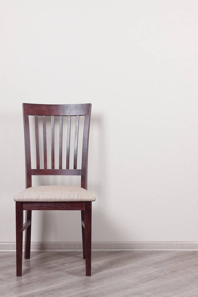 Wooden Chair with Cushion Against a White Wall - Foto, Bild
