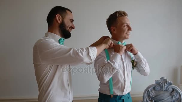 Groomsman aiutare lo sposo con il suo vestito
 - Filmati, video