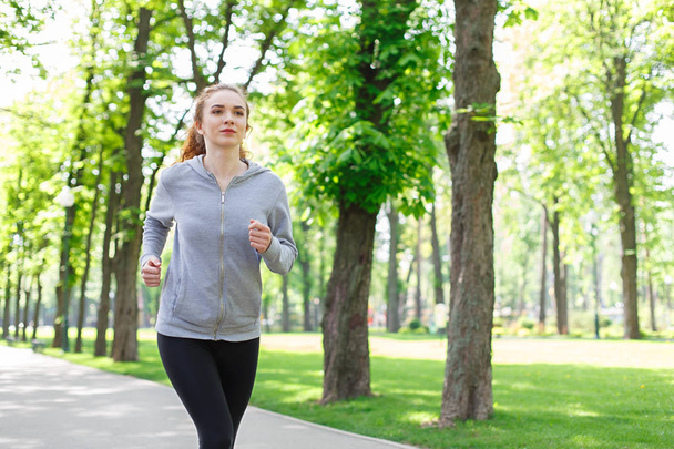Молода жінка біжить у зеленому парку, копіює простір
 - Фото, зображення