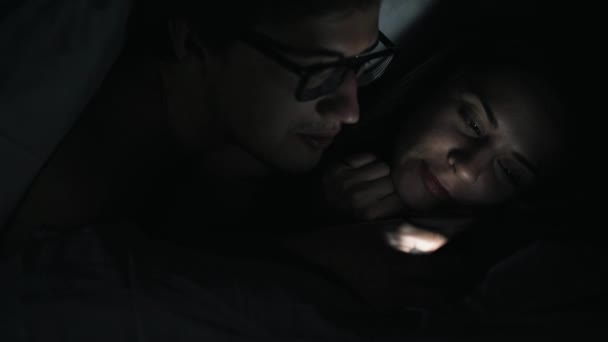 Ζευγάρι σε ένα σκοτεινό δωμάτιο με ένα smartphone - Πλάνα, βίντεο