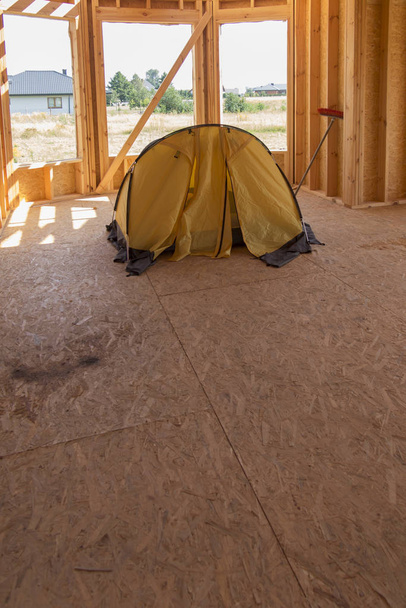tenda gialla piantata all'interno della casa costruita
 - Foto, immagini