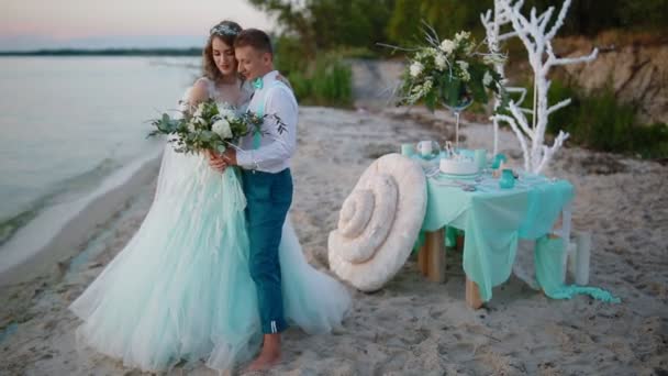 Menyasszony és a vőlegény pózol a tenger közelében - Felvétel, videó