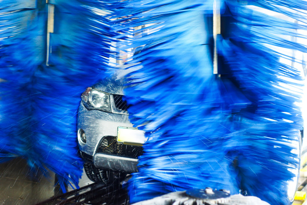 Lavado de autos, coche negro en lavado automático de autos, cepillo rojo y azul giratorio. Vehículo de lavado
. - Foto, imagen