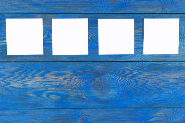 White blank cards on blue wooden table with copy space. Creative reminder, small sheets of paper on desk with empty space for text, light memo background,  - Φωτογραφία, εικόνα