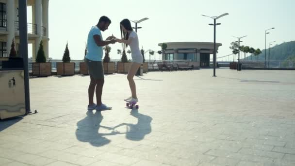 Romantic couple practicing skateboarding on the city street - Materiaali, video