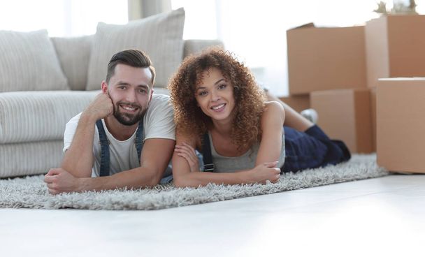 Happy couple lies on the floor in a new apartment - Foto, afbeelding