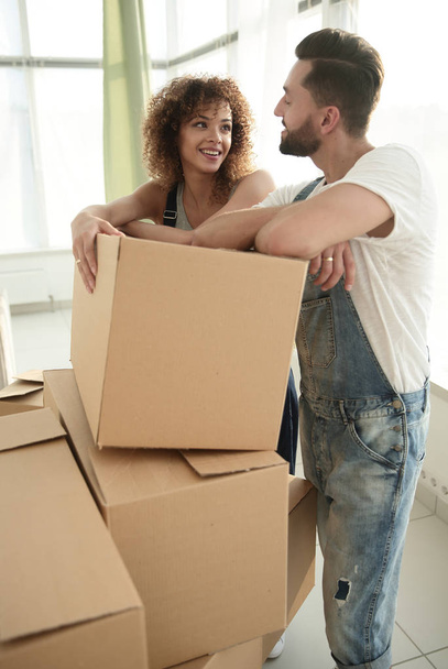 Glückliches Paar steht neben Kisten in seiner neuen Wohnung. - Foto, Bild