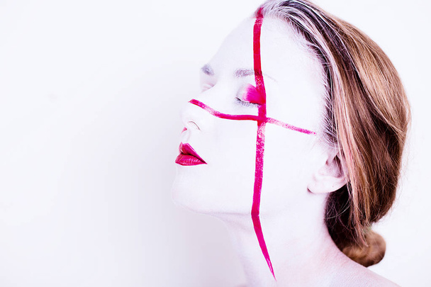 Beauty portrait of girl with white face with red stripes and red lips  - Фото, зображення