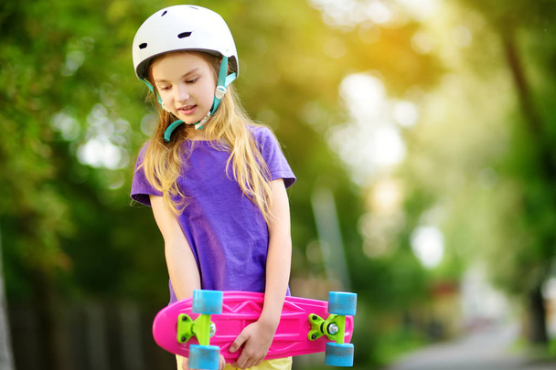 little girl learning to skateboard in park - Фото, зображення