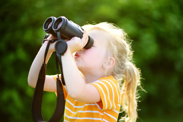 little girl looking through binoculars  - Foto, Bild