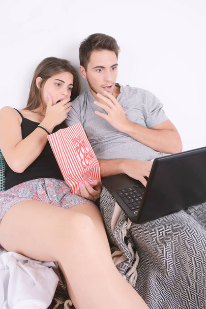 Couple watching movies in bed. - Фото, изображение