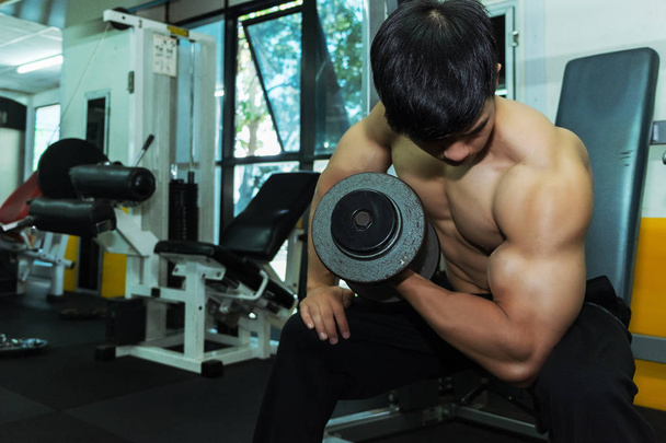 Fitness άνθρωπος στην κατάρτιση δείχνει ασκήσεις με αλτήρες στο γυμναστήριο, fitness έννοια, έννοια του αθλητισμού - Φωτογραφία, εικόνα
