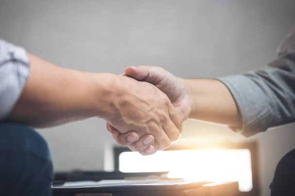 Two business men shaking hands during a meeting to sign agreemen - Fotoğraf, Görsel