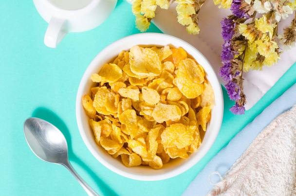 Cornflakes in een kom met lepel voor eten in de ochtend - Foto, afbeelding