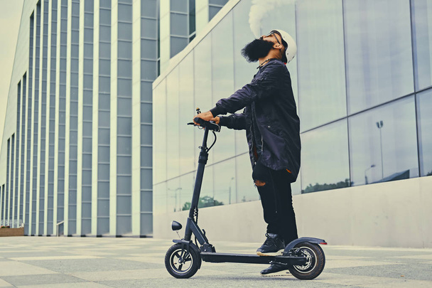 vaping maschile e guida in scooter elettrico
 - Foto, immagini