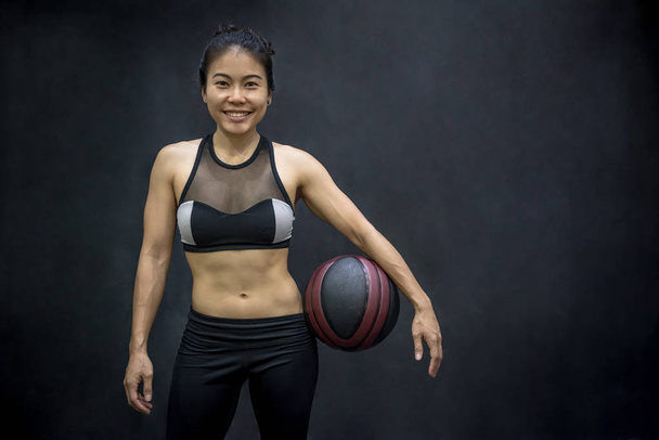 Jeune femme asiatique en tenue de sport tenant basket
 - Photo, image