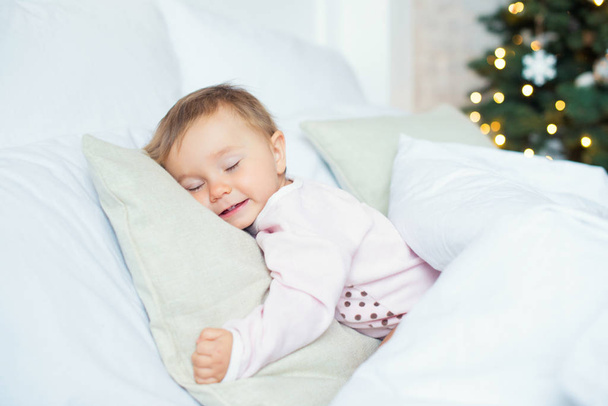 Criança menina dormir em sua cama na manhã de Natal
 - Foto, Imagem