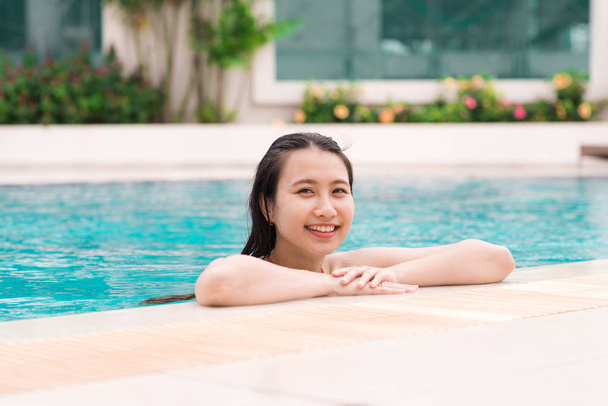 schöne asiatische Frau lächelt in einem Schwimmbad - Foto, Bild