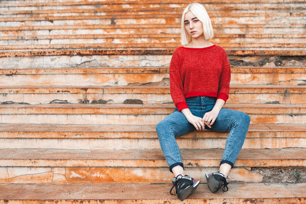 blonde girl sitting on rusty stairs - Photo, image