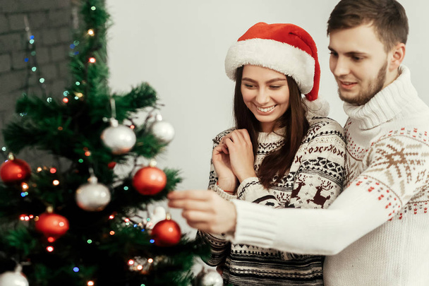 女と男のクリスマス ツリーを飾る - 写真・画像