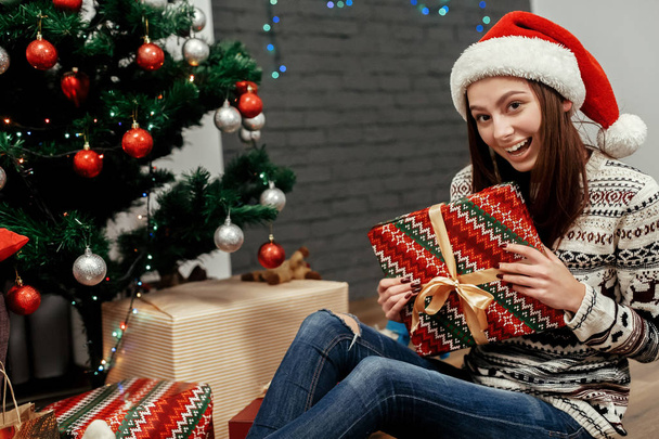 Frau sitzt mit Weihnachtsgeschenken - Foto, Bild