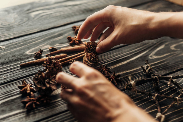 hands arranging anise and pine cones - Foto, Imagem