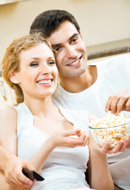 Young couple eating popcorn and watching TV - Photo, image