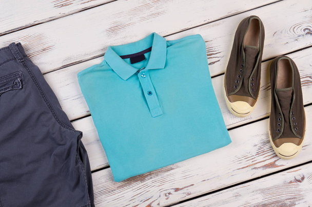 Μπλε πόλο t-shirt, πάνινα παπούτσια, σορτς. - Φωτογραφία, εικόνα