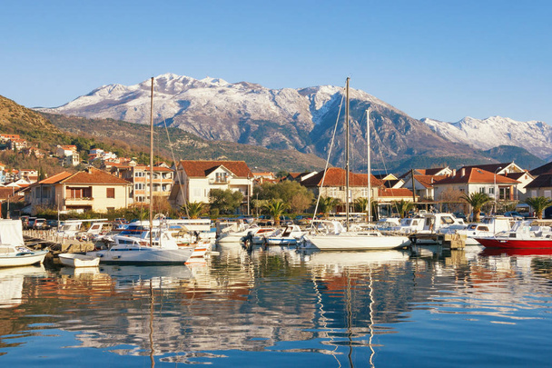 Vissersboten in de haven. Marina Kalimanj in Tivat stad op een zonnige winterdag met Lovcen berg op de achtergrond, Montenegro - Foto, afbeelding