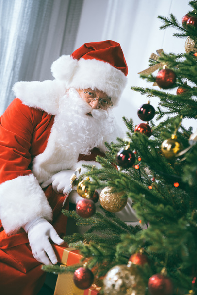 santa claus with christmas gift - Фото, изображение