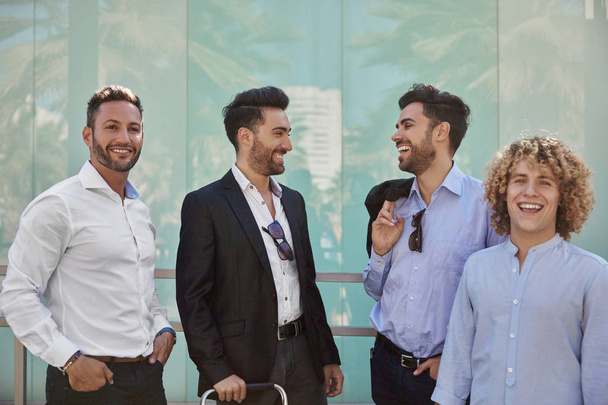 Quatro empresários de pé juntos rindo
 - Foto, Imagem
