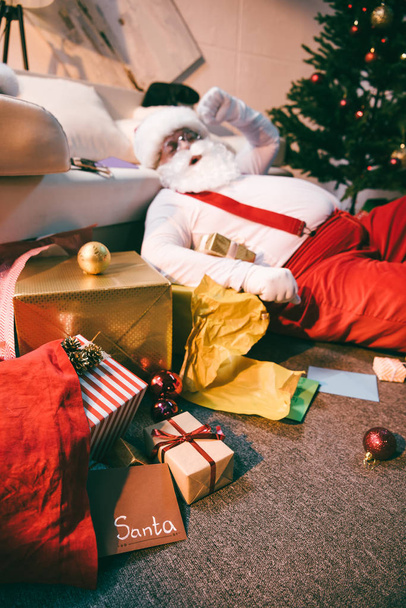Санта Клаус лежить на підлозі
 - Фото, зображення