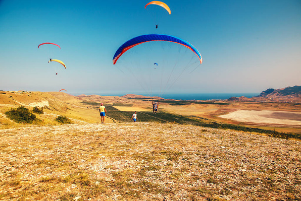 Paragliders fly over the valley. - Fotoğraf, Görsel