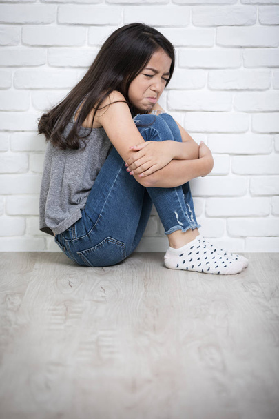 Depresso giovane ragazza asiatica seduta sul pavimento a casa
 - Foto, immagini