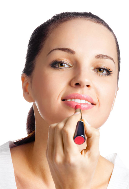 portrait of young woman applying lipstick, isolated - Фото, зображення