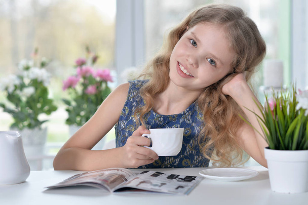 little girl reading magazine - Фото, изображение