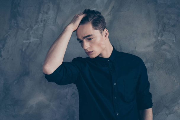Young fashionable guy in black shirt touching his hair and posin - Фото, зображення