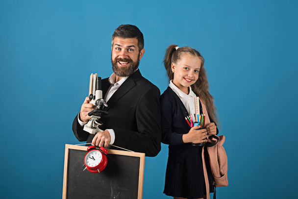 Man with beard and girl in uniform. Teacher and schoolgirl - Photo, Image