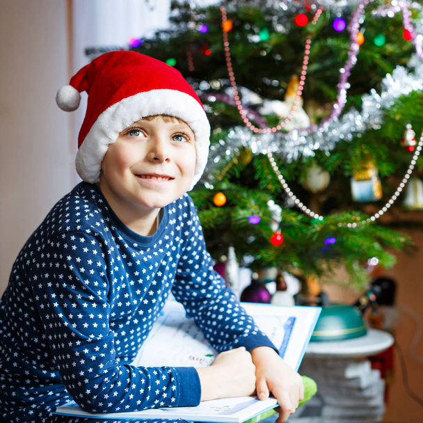 little school kid boy reading a book on Christmas - Foto, immagini