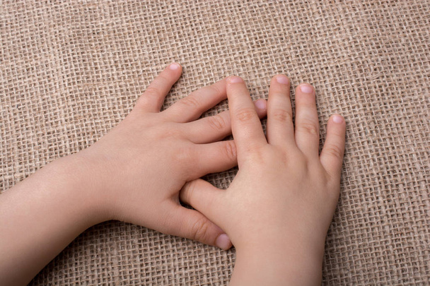 Toddler mão com tela de fundo de linho
 - Foto, Imagem