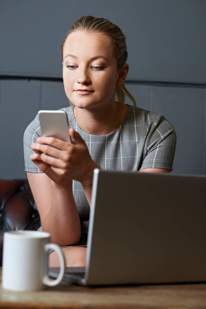 Деловая женщина с мобильным телефоном работает на ноутбуке в Интернете Ca
 - Фото, изображение