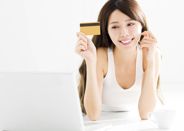 Счастливая молодая женщина, покупающая онлайн с помощью кредитной карты
 - Фото, изображение