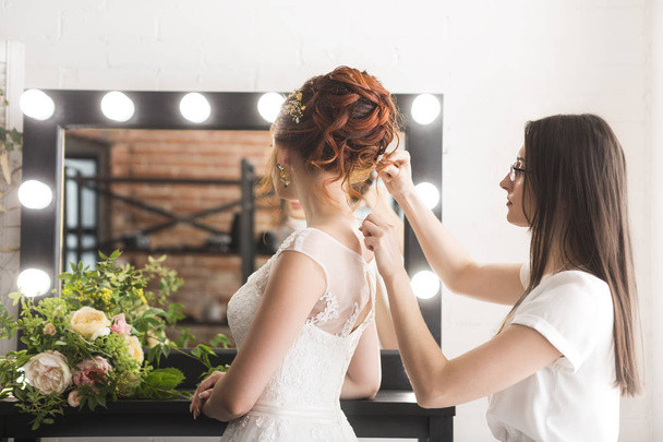Fiatal szép menyasszony és a stúdió előtt esküvő stylist - Fotó, kép