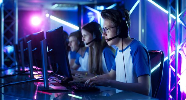 Team of Teenage Gamers Play in Multiplayer PC Video Game on a eSport Tournament. Captain Gives Commands into Microphone, Trying Strategically Win the Game. - Valokuva, kuva