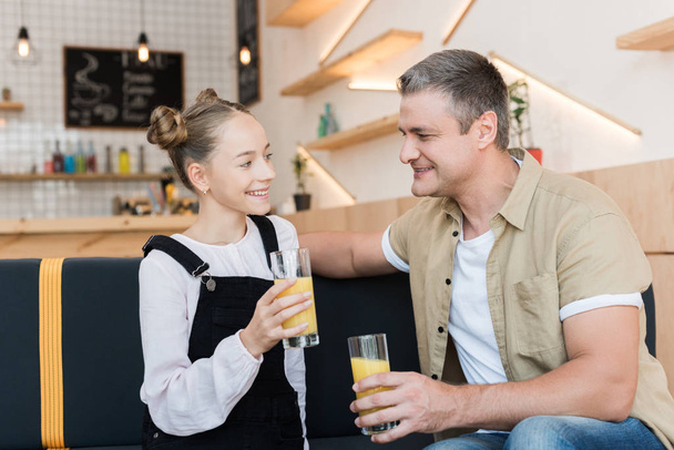 father and daughter with orange juice - Photo, Image