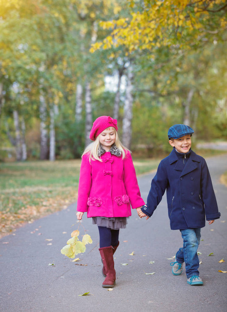 Children walking in beautiful autumn park on warm sunny fall day. - Photo, Image
